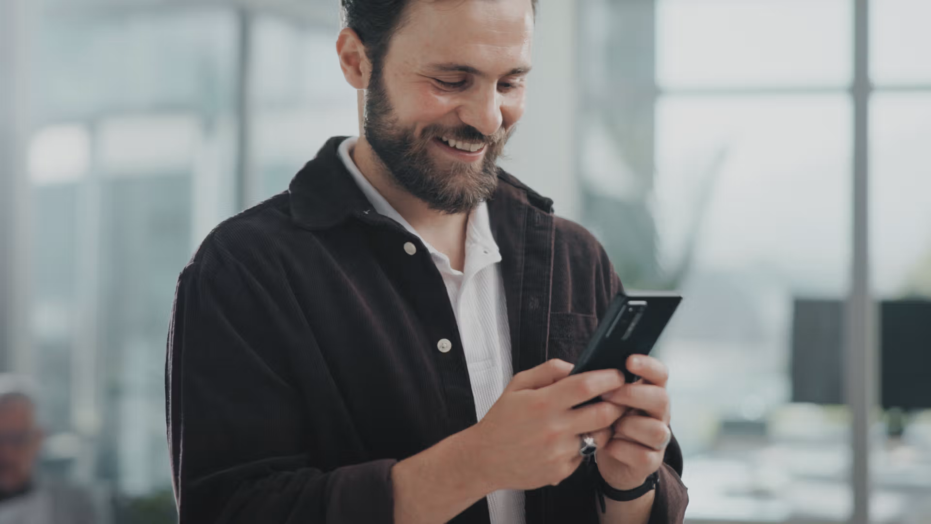 Homme souriant consultant un smartphone